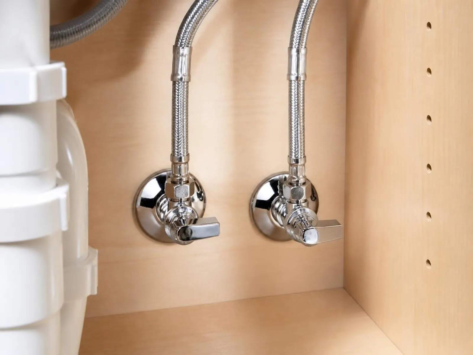 New chrome shutoff valves and braided supply lines under a sink