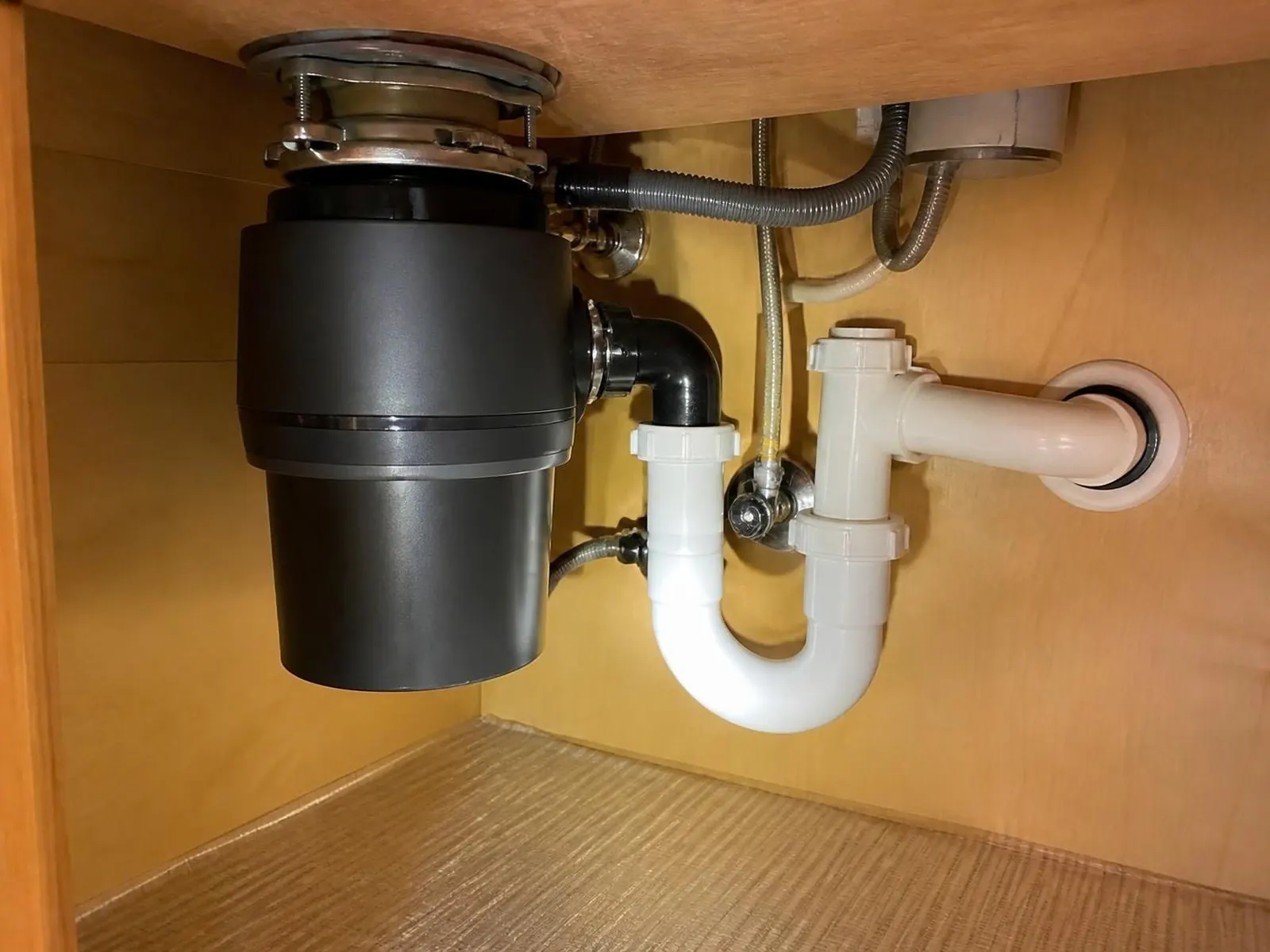 Garbage disposal and drain trap under a kitchen sink